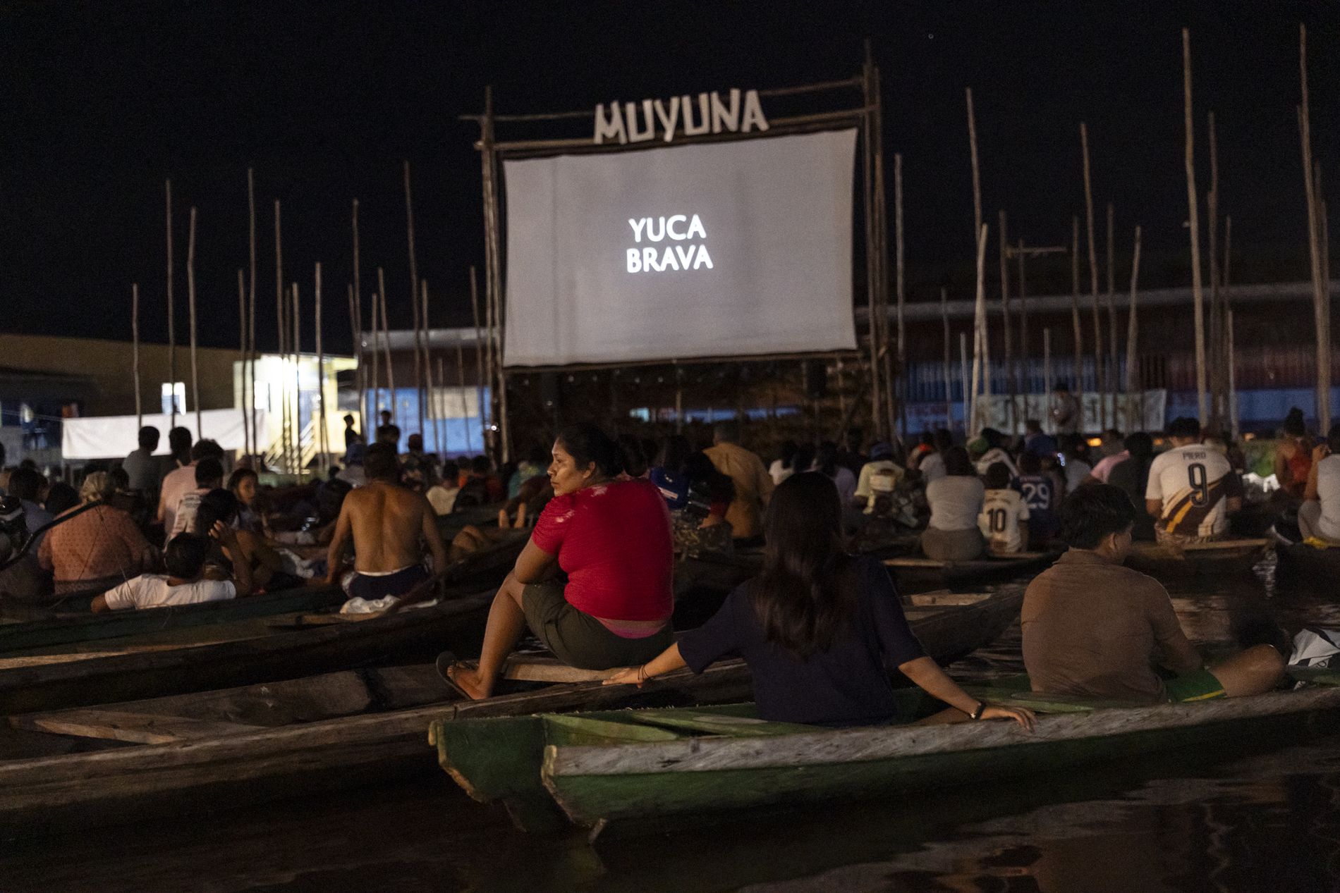 Película proyectada ante una audiencia en canoas