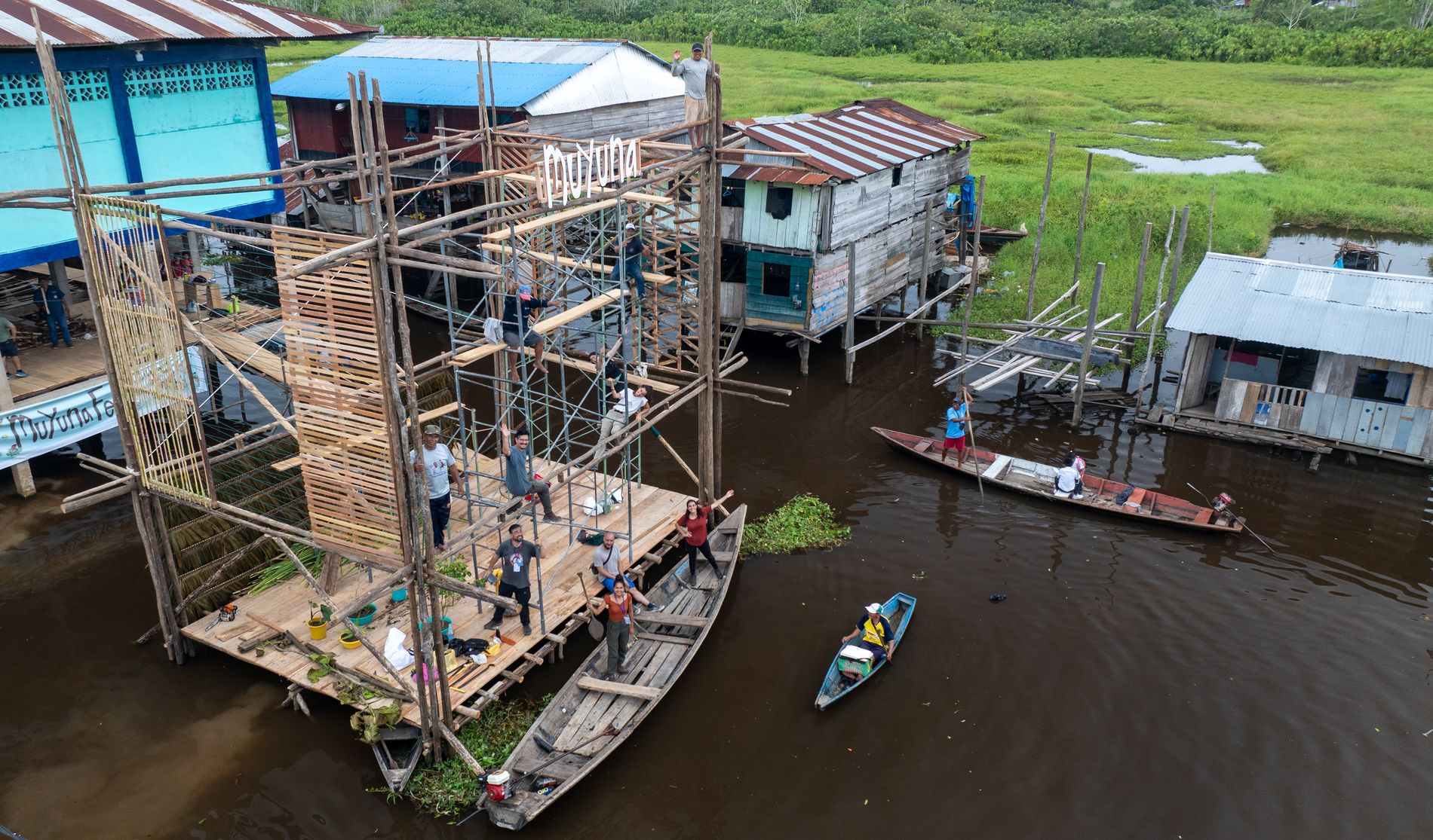 Vista aérea de la construcción del escenario flotante entre casas y canoas