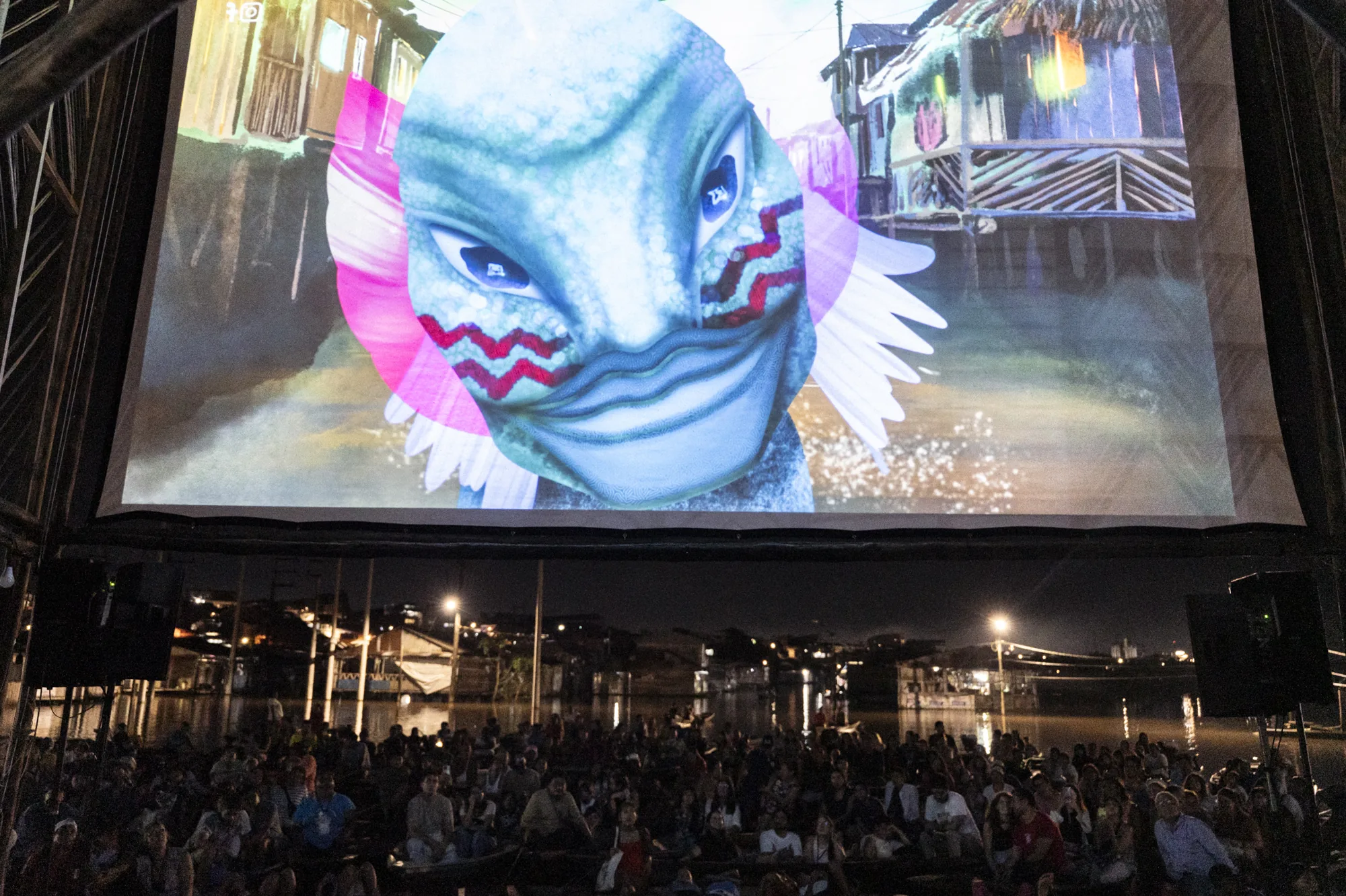 Una animación proyectada en la pantalla flotante ante el público en canoas
